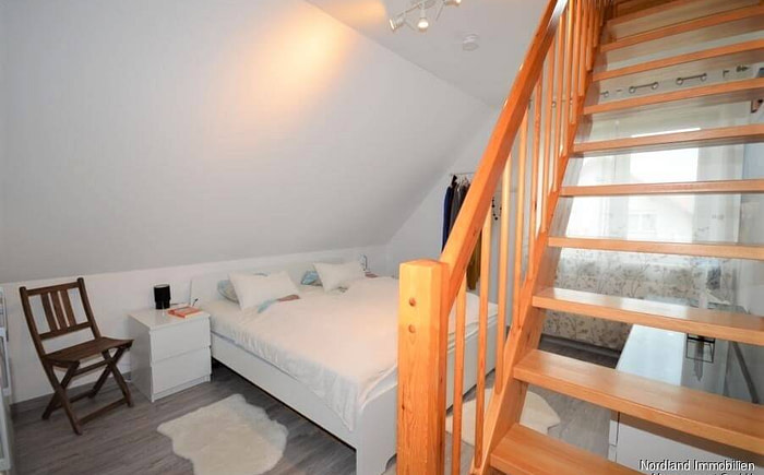 Schlafzimmer mit Treppe zum ausgebauten Dachboden