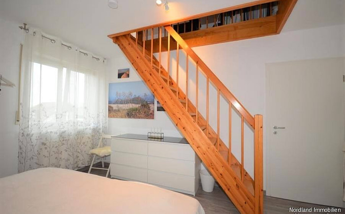 Schlafzimmer mit Treppe zum ausgebauten Dachboden